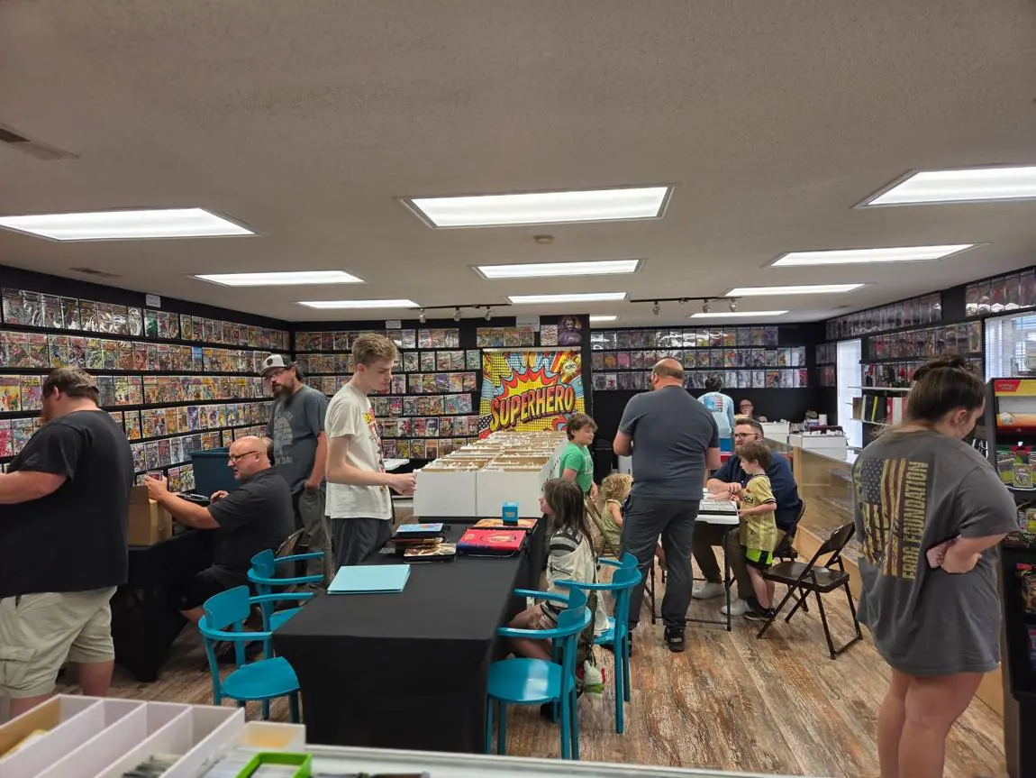 A packed Trade Night: kids and adults trading Pokémon binders at the tables